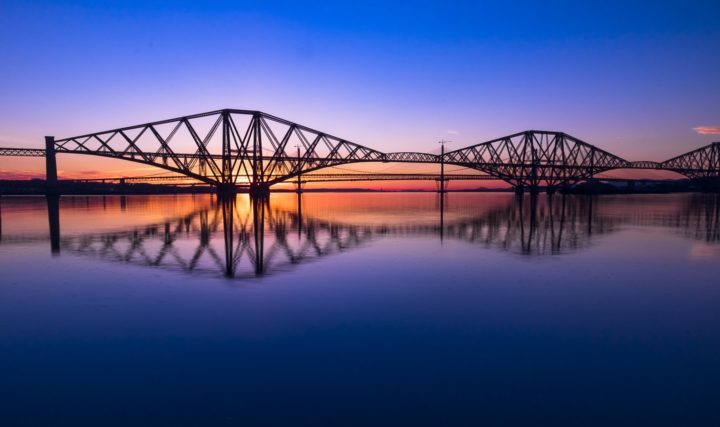 bridge night sun set colour blue red orange yellow reflection water calm river