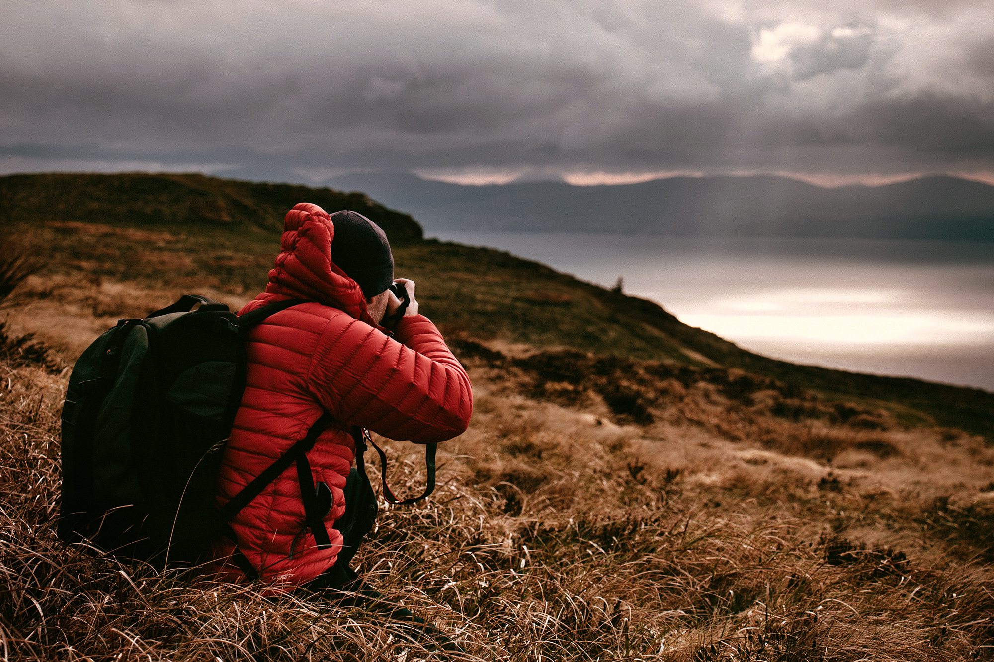 photographer field hillside sunset lake water countryside location camera red