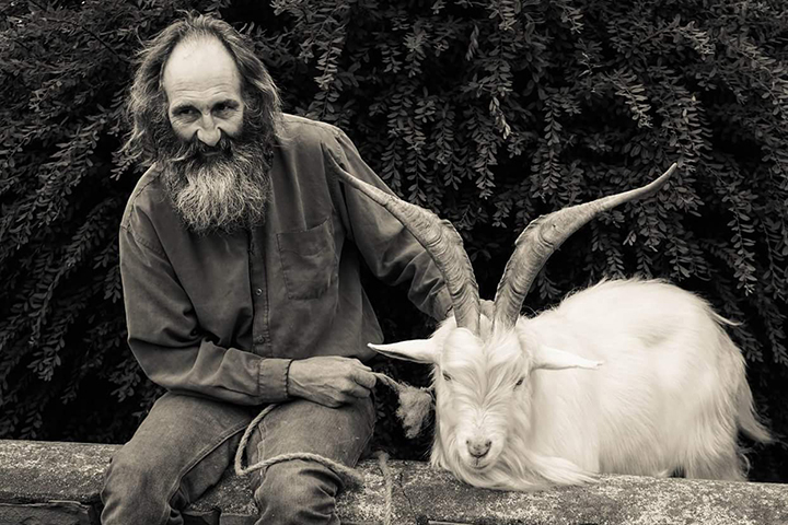 man sat with goat on a wall street photography portrait city people camera subject light how to tutorial guide